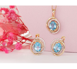 Złote kolczyki i zawieszka z niebieskim oczkiem