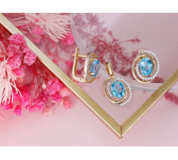 Złote kolczyki i zawieszka z niebieskim oczkiem